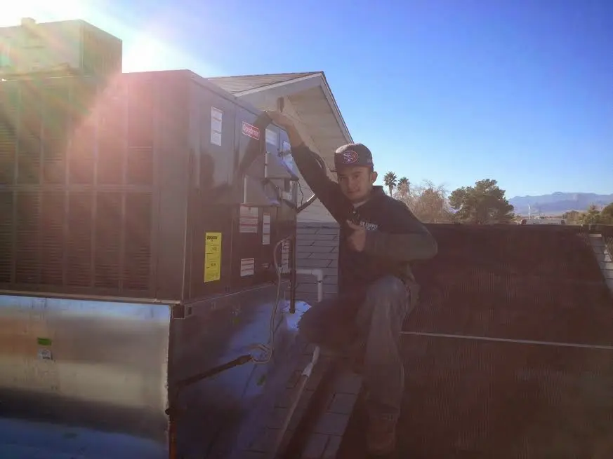 HVAC technician performing HVAC Inspection on a rooftop unit in Little Canada